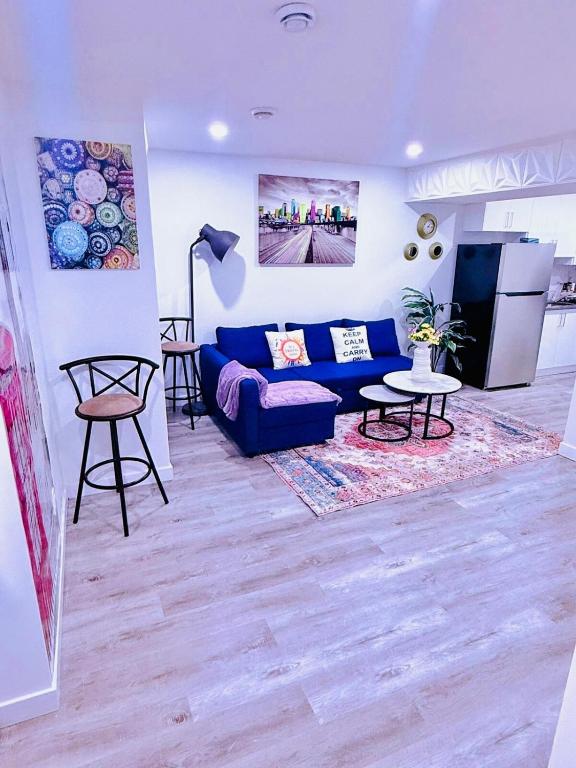 a living room with a blue couch and a table at Modern Comfort Stay Near Airport in Edmonton