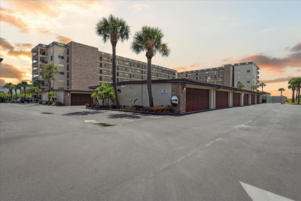 un aparcamiento con un edificio y palmeras en Windrush 509, en Cocoa Beach