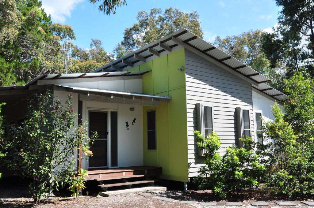 a small house with green and white paint at Csalt - Rainbow Shores in Rainbow Beach