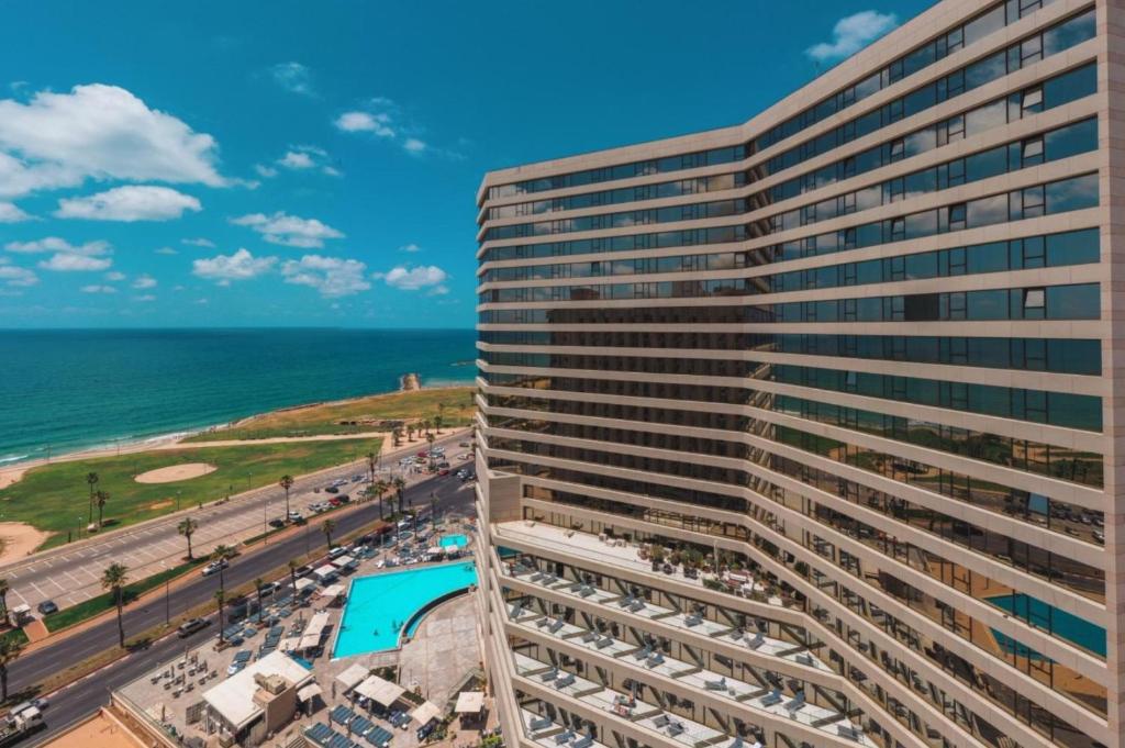 テルアビブにあるInterContinental David Tel Aviv by IHGのビーチと海を見下ろす高層ビル