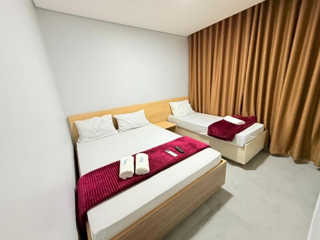 Una habitación de hotel con dos camas y una ventana. en Hotel Vision Guaianases, en São Paulo