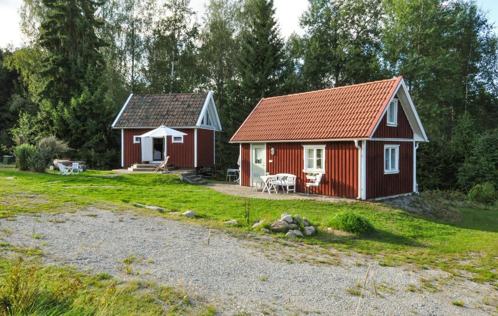 a small red house with a porch and a table at 3 Bedroom Cozy Home In Brunskog in Vikene