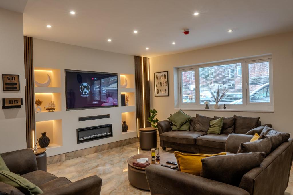 a living room with a couch and a tv at Luxehaus MCR in Manchester