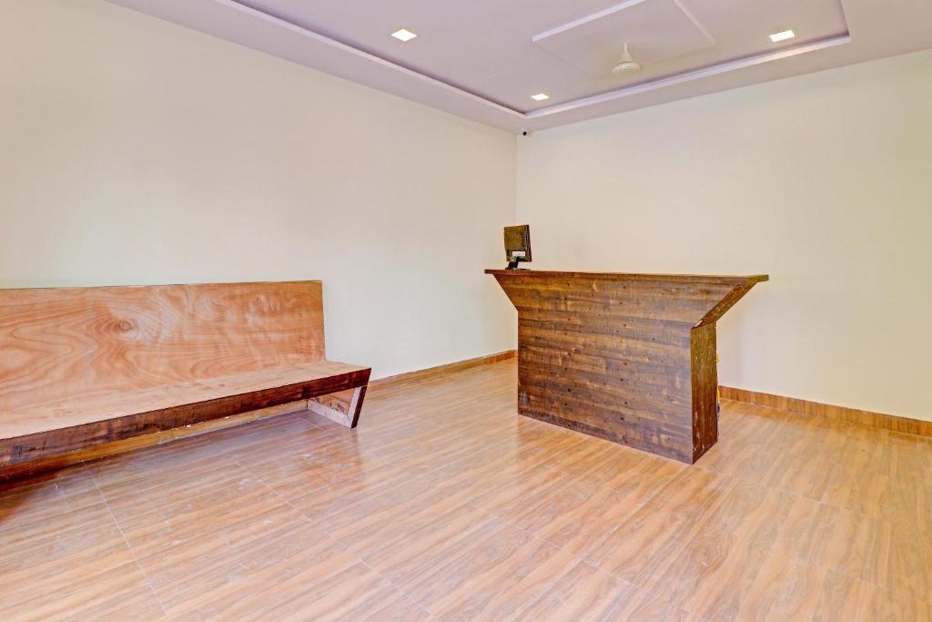 um quarto com um banco de madeira no meio de uma parede em Hotel O Abhi's R Square em Upal