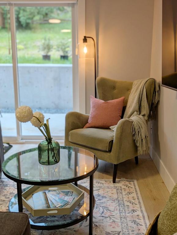 a living room with a chair and a glass table at Oakview Hideaway in Victoria