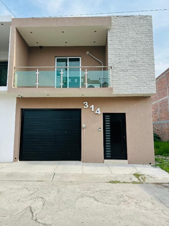 a house with two garage doors and a balcony at Casa de lujo muy cómoda de 2 pisos in San Miguel el Alto