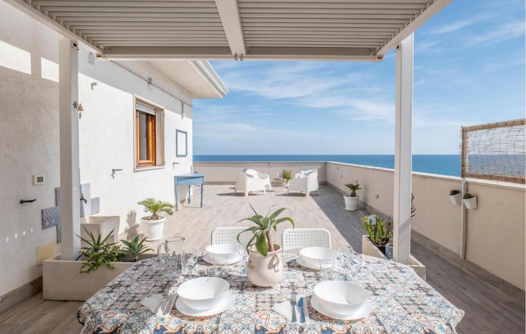 eine Terrasse mit einem Tisch und Meerblick in der Unterkunft Amazing Apartment In Pozzallo With Wifi in Pozzallo