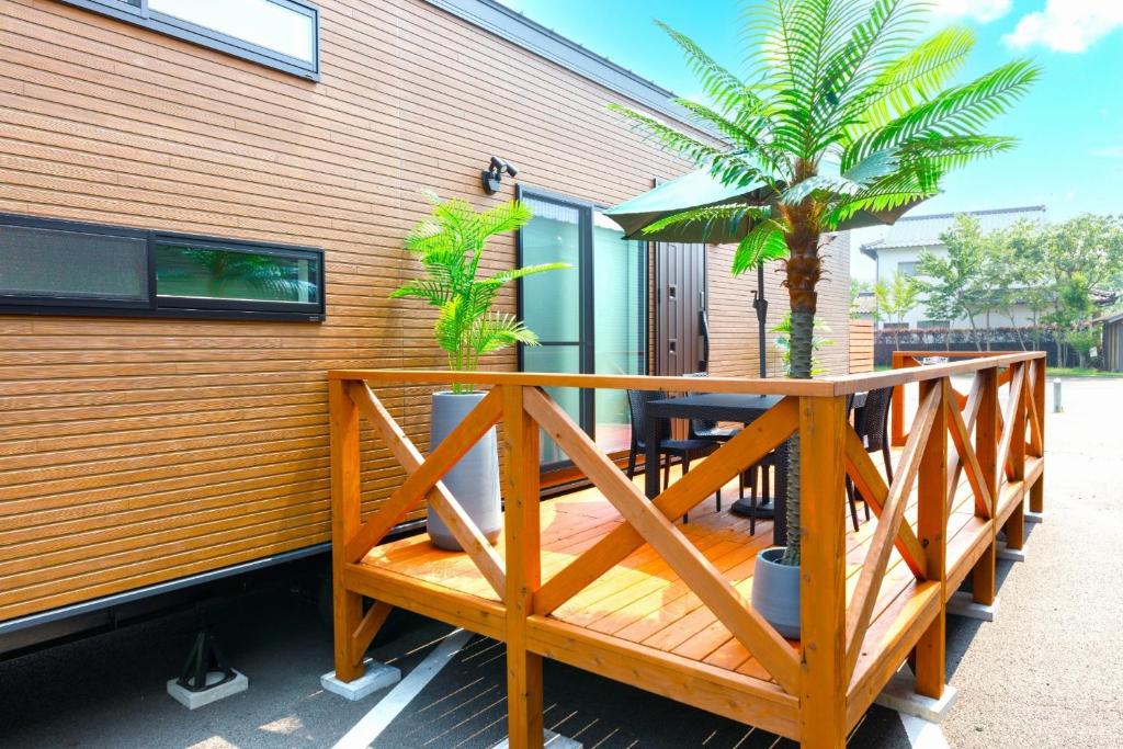 a wooden deck with a table and a palm tree at Trailer Ship Garden Aso - Vacation STAY 96758v in Aso
