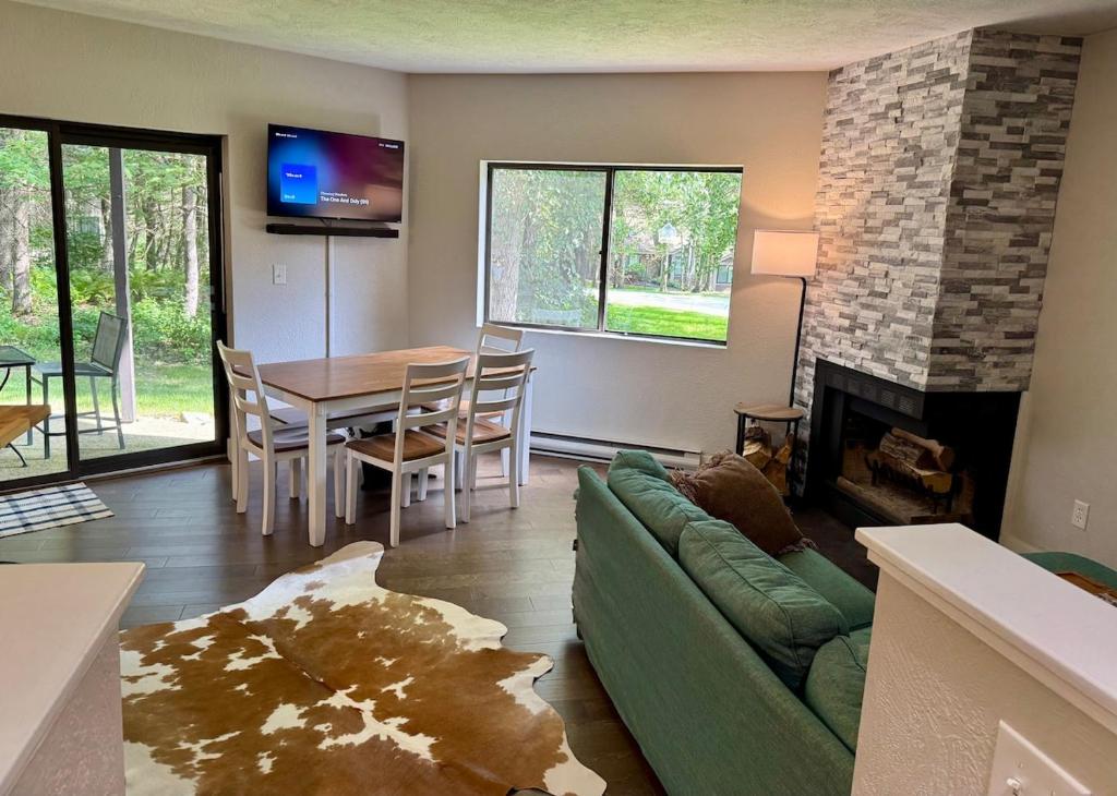 un soggiorno con divano verde e camino di Contemporary Ski Condo a Bakersville