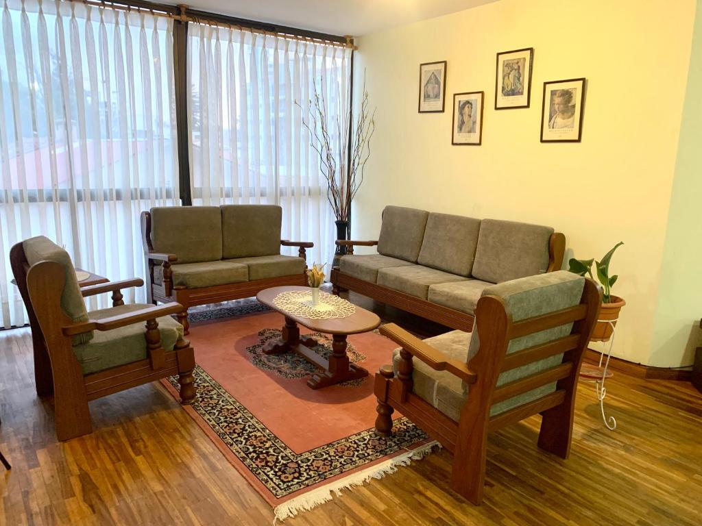salon z dwoma krzesłami i kanapą w obiekcie Serenity Apartment w mieście Cochabamba