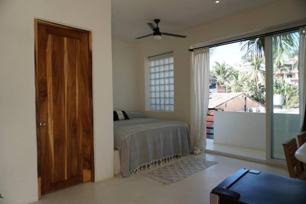 a bedroom with a bed and a large window at Nicho Suite @ Sayulita Surfside Suites in Sayulita
