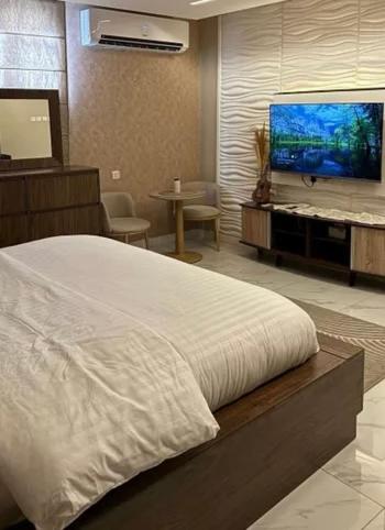 Un dormitorio con una cama y un televisor de pantalla plana. en شقق المحبة, en Taif