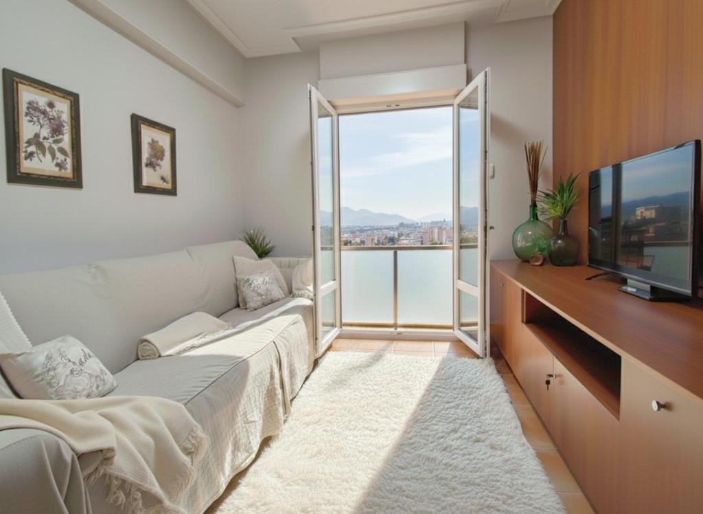 a living room with a couch and a television at COSTA VASCA LEIOA - HoME in Leioa