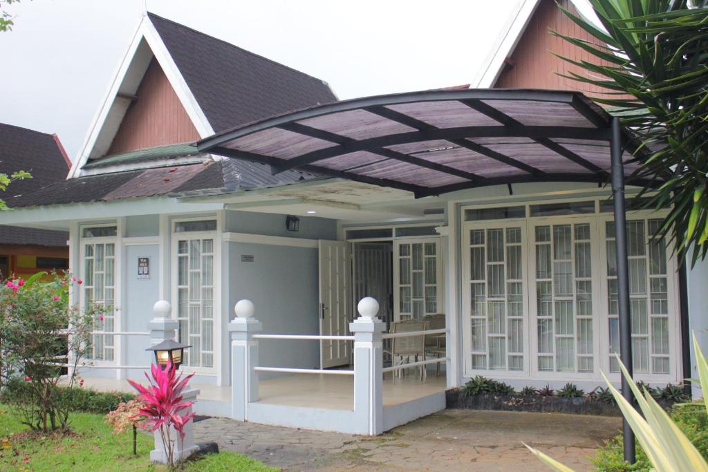 a screened in porch of a house with awning at Diyar Villas Puncak M3/8 in Puncak
