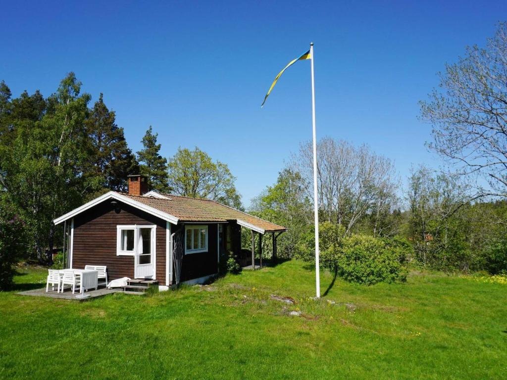 a small house with a flag pole in a yard at 4 person holiday home in Tyresö in Tyresö