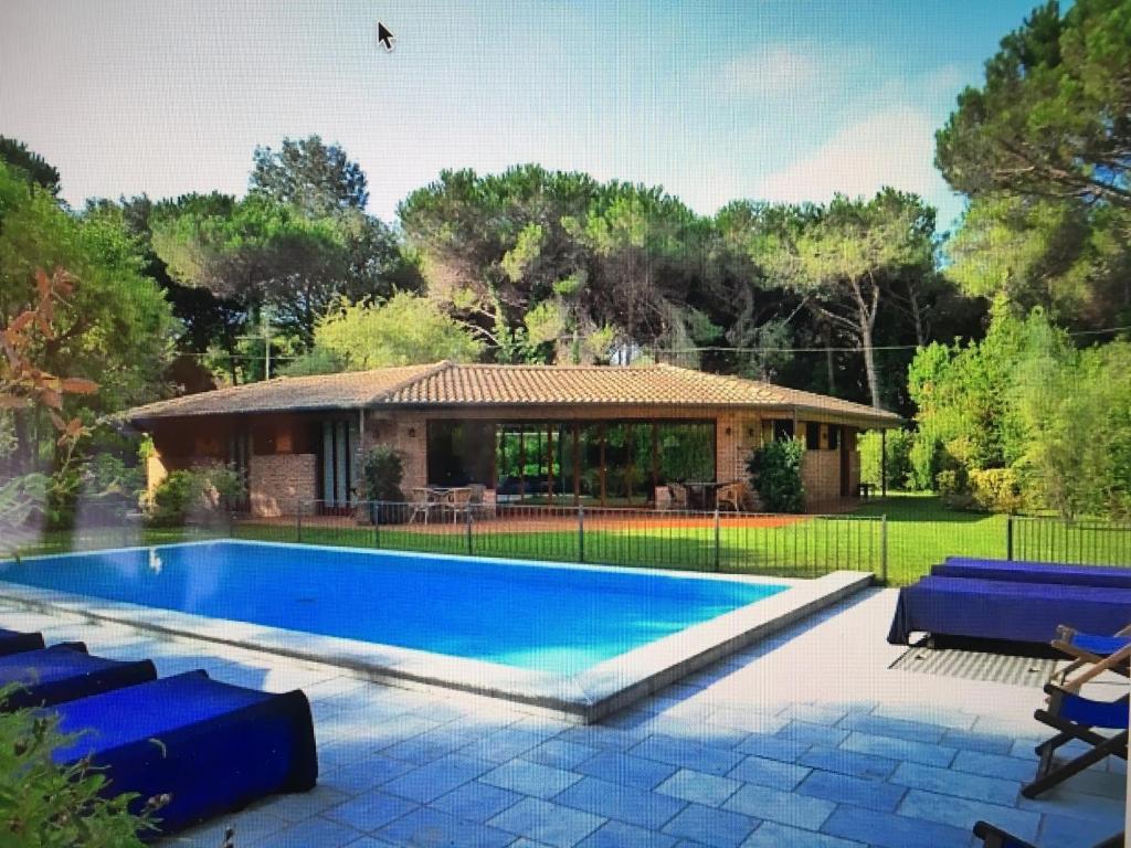 a swimming pool in front of a house at Villa Sibel con piscina in Versilia in Massa
