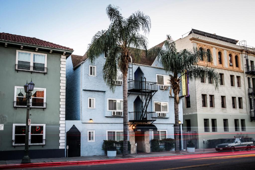 uma fila de edifícios numa rua com palmeiras em The Hotel Hollywood em Los Angeles