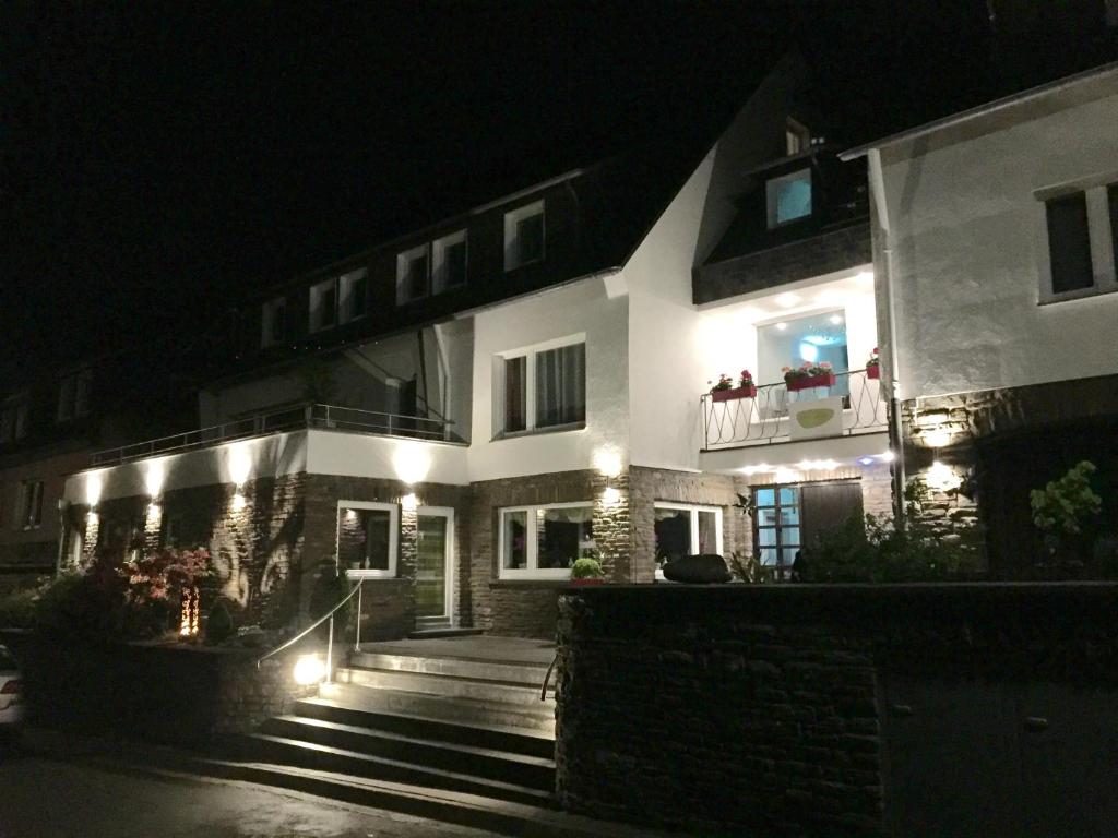 a large white building with people on a balcony at night at Hotel Vintage Am Bundesbank-Bunker in Cochem