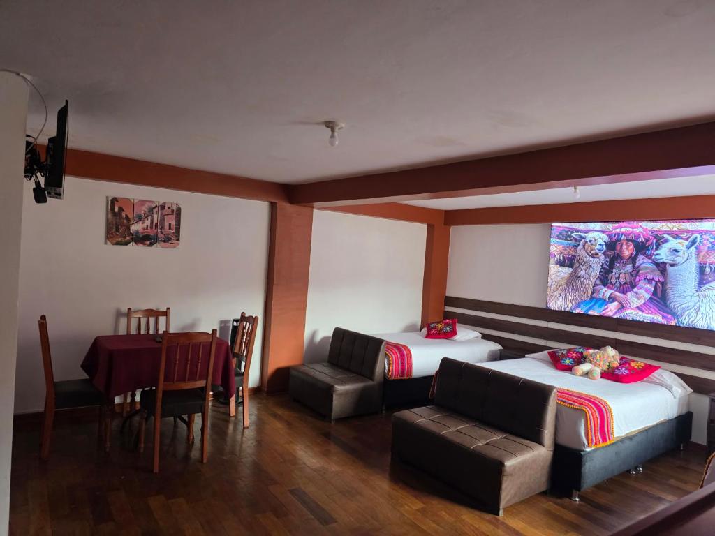 a room with two beds and a table and a tv at All Sur cusco in Cusco