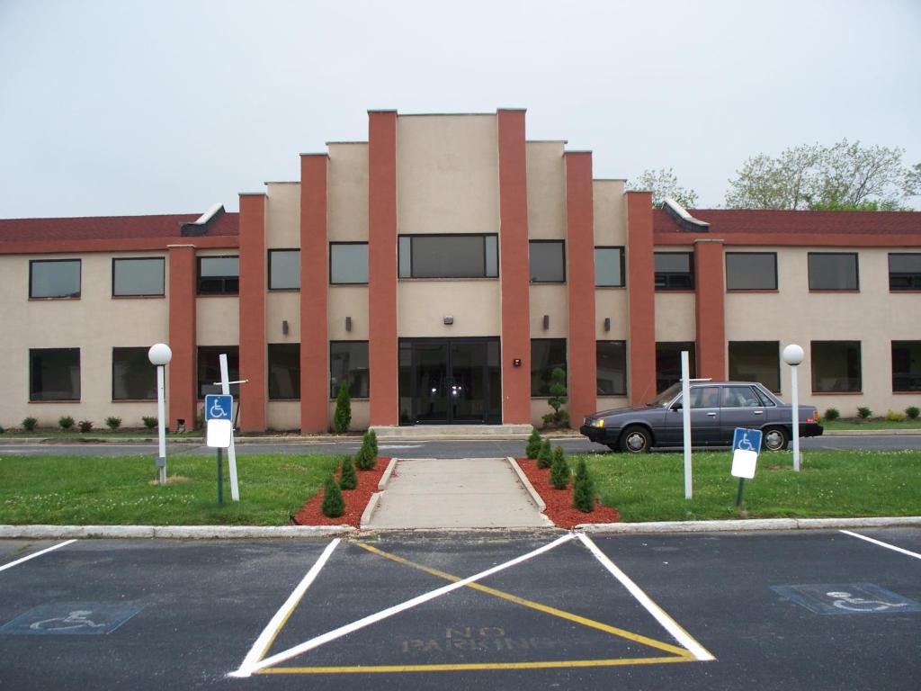 um parque de estacionamento em frente a um grande edifício em Budget Inn & Suites em Wall Township