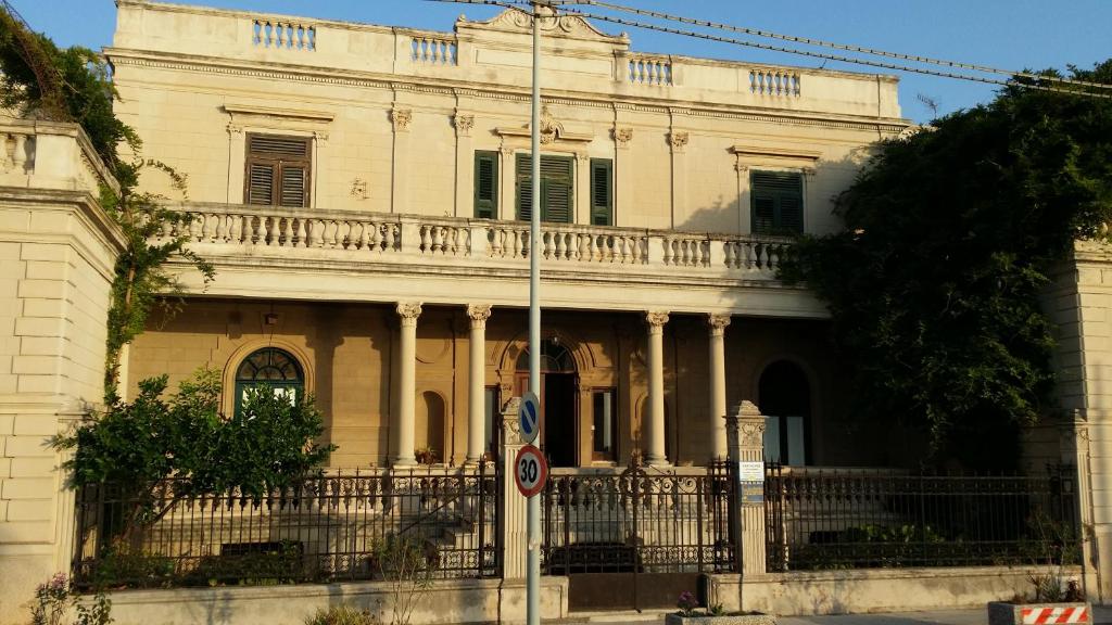 利帕里的住宿－阿爾瓦特羅斯住宿加早餐旅館，前面有旗帜的大型白色建筑