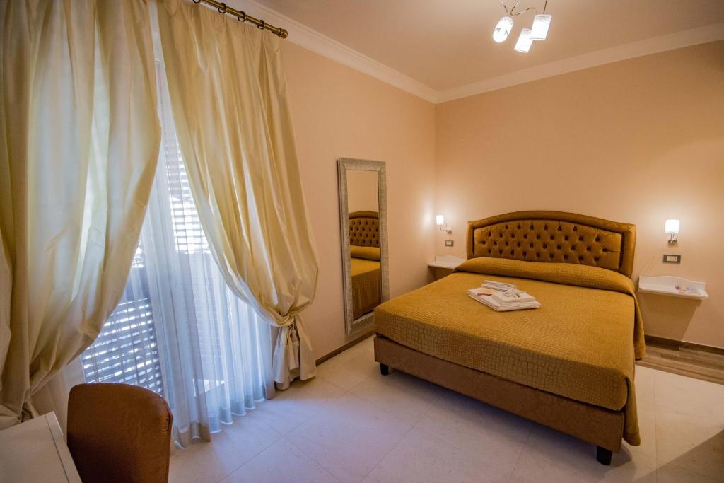 a bedroom with a bed and a large window at Sogno D'Epoca 1822 in Monopoli
