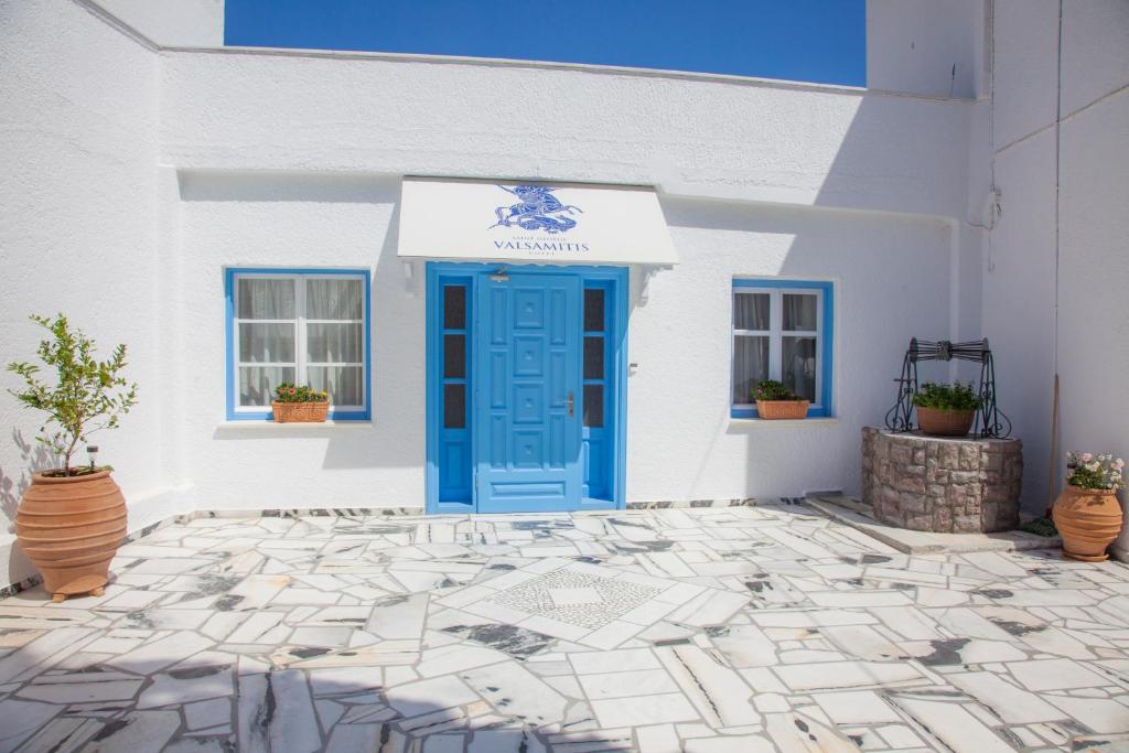 a blue door on a white building with potted plants at St.George Valsamitis in Katapola