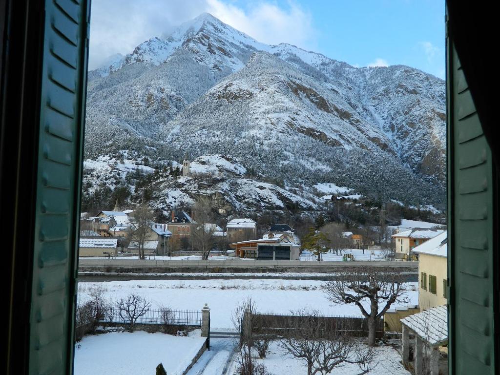 - une vue sur une montagne enneigée depuis une fenêtre dans l'établissement Chambre d'Hotes La Mexicaine, à Jausiers