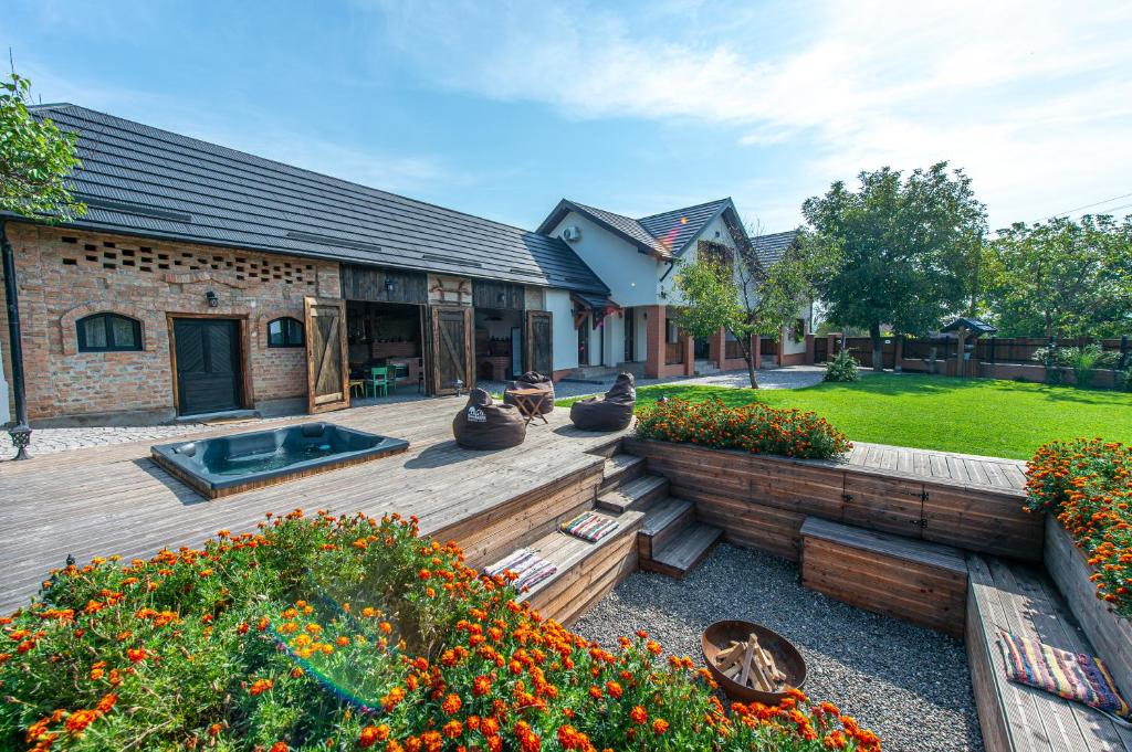 a backyard with a wooden deck with flowers at Old Barn House in Vàrhegy