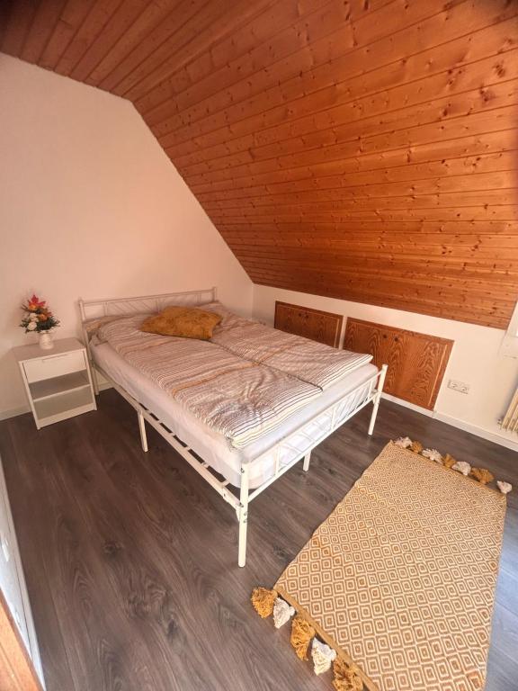 a bed in a room with a wooden ceiling at Altstadt Nest im Herzen der Stadt in Villingen-Schwenningen