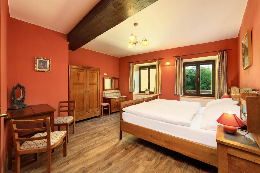 捷克克魯姆洛夫的住宿－坢休恩泰迪酒店，一间卧室设有红色的墙壁、一张床和一张书桌