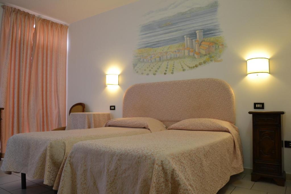 a bedroom with a bed and two lights on the wall at Hotel Ristorante Bagnaia in Viterbo