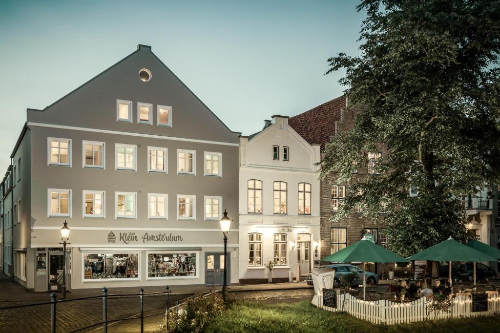 a large white building with a restaurant in front of it at Hotel Klein Amsterdam in Friedrichstadt