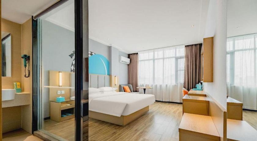 ein Schlafzimmer mit einem weißen Bett und einem großen Fenster in der Unterkunft City Comfort Inn Dangtu High Speed East Railway Station RT-Mart in Dangtu