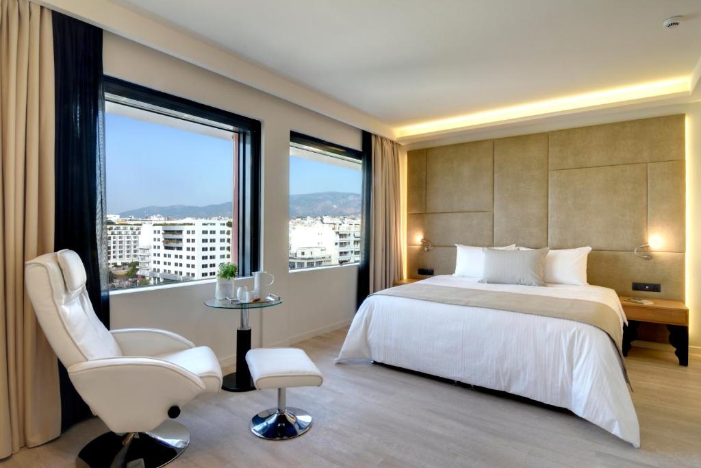 um quarto com uma cama e uma grande janela em Athens Avenue Hotel em Atenas