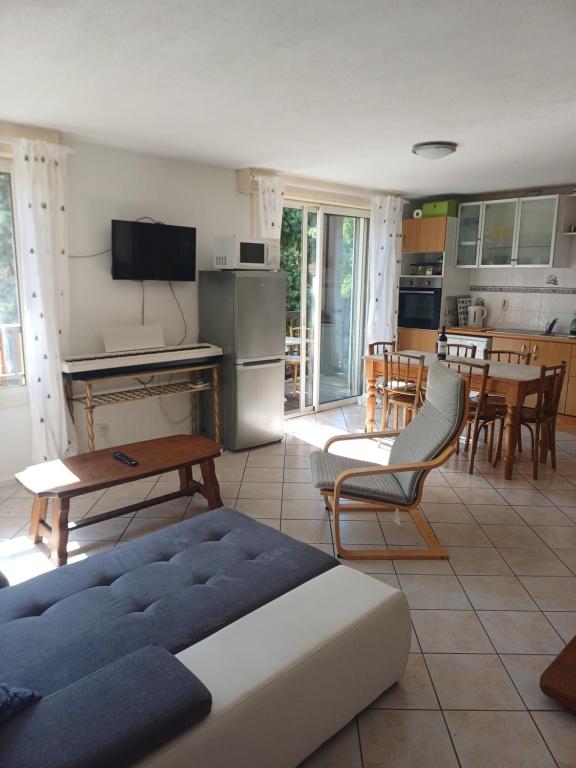 a living room with a couch and a table and a kitchen at Cazharil in Mauléon-Barousse