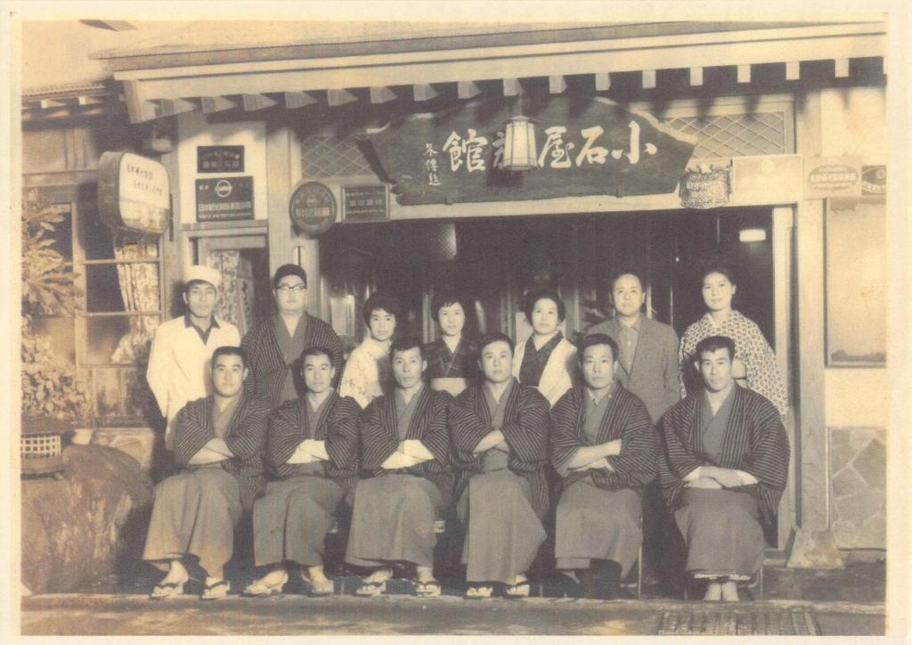 ein altes Foto einer Gruppe von Leuten vor einem Laden in der Unterkunft Shibu Onsen Koishiya Ryokan in Yamanouchi