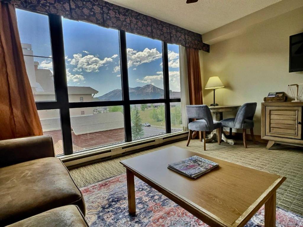 a living room with a large window with a view at King Suite with a View Pool Hot Tub Ski In-Out in Mount Crested Butte