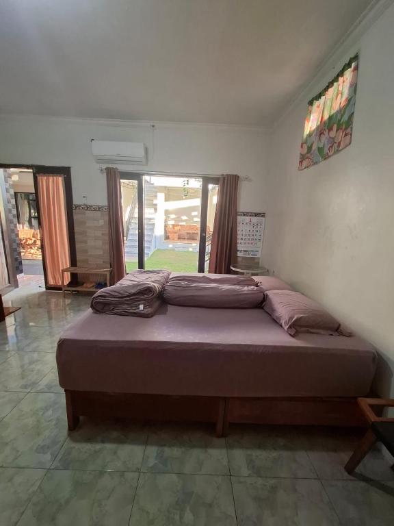 a bedroom with a large bed in a room with windows at Bali House in Keramas