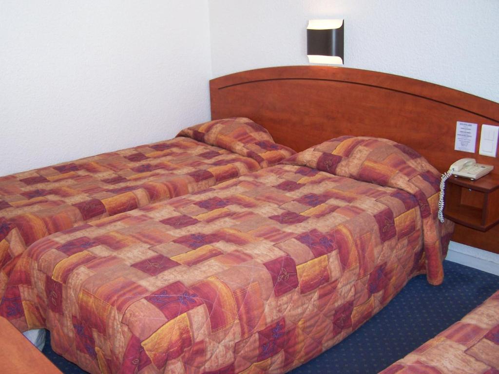 Postel nebo postele na pokoji v ubytování Hôtel Estival Arriel