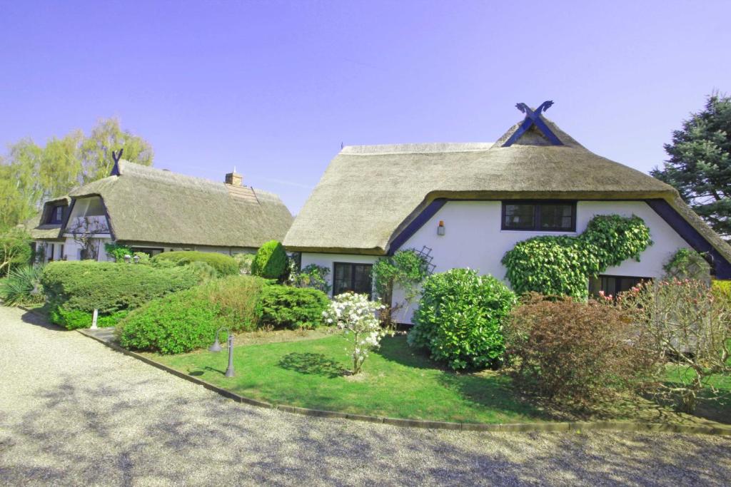 a large white house with a thatched roof at Landhaus Darss in Wieck