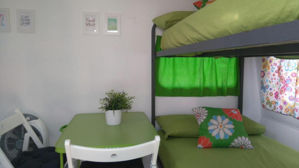トレブランカにあるCamping Torrenostraのテーブルと二段ベッドが備わる客室です。