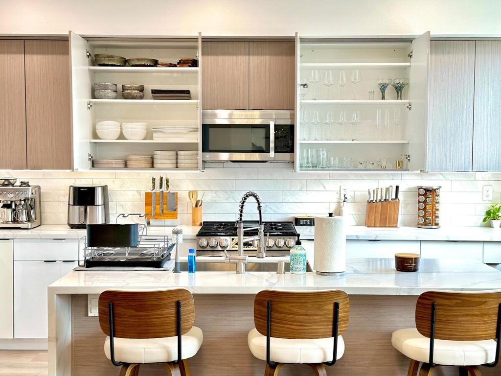 Una cocina con una encimera con sillas y un fregadero. en Modern 5BR Luxury Paradise Villa, en Los Ángeles