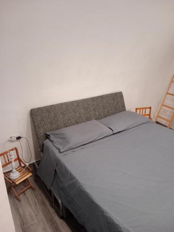a bedroom with a bed with a gray mattress and two chairs at Casa Vacanza Altamura in Altamura
