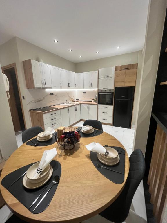 una cocina con una mesa de madera con sillas alrededor. en KN Luxury Apartment, en Alexandroupoli