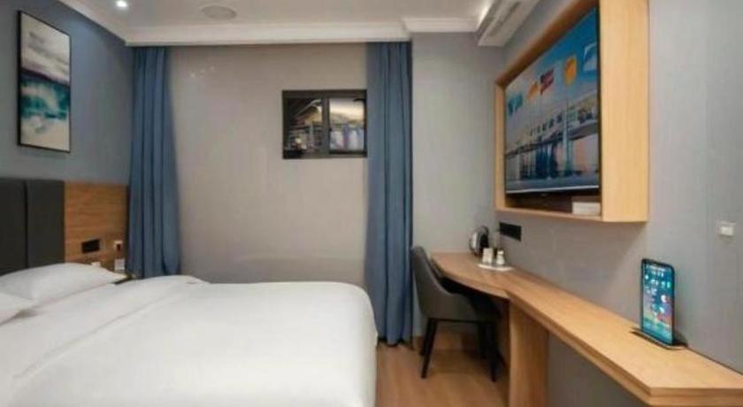 ein Schlafzimmer mit einem Bett und einem Schreibtisch mit einem Computer in der Unterkunft GreenTree Inn Shanghai Luojing Express Hotel in Luojing