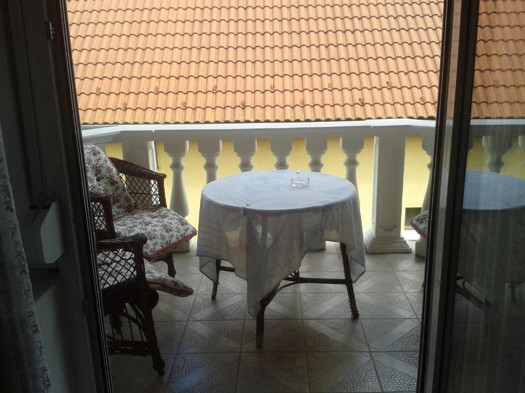 een tafel en stoelen op een balkon met een wit tafelkleed bij Ilda Apartments in Harkány