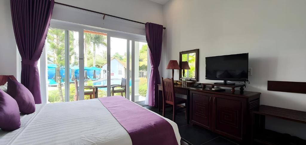 a bedroom with a bed and a desk and a television at Terrace Phú Quốc in Phu Quoc