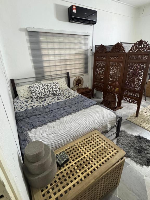 a bedroom with a bed with a wooden bed frame at Cozy Nature Homestay in Kuala Lumpur