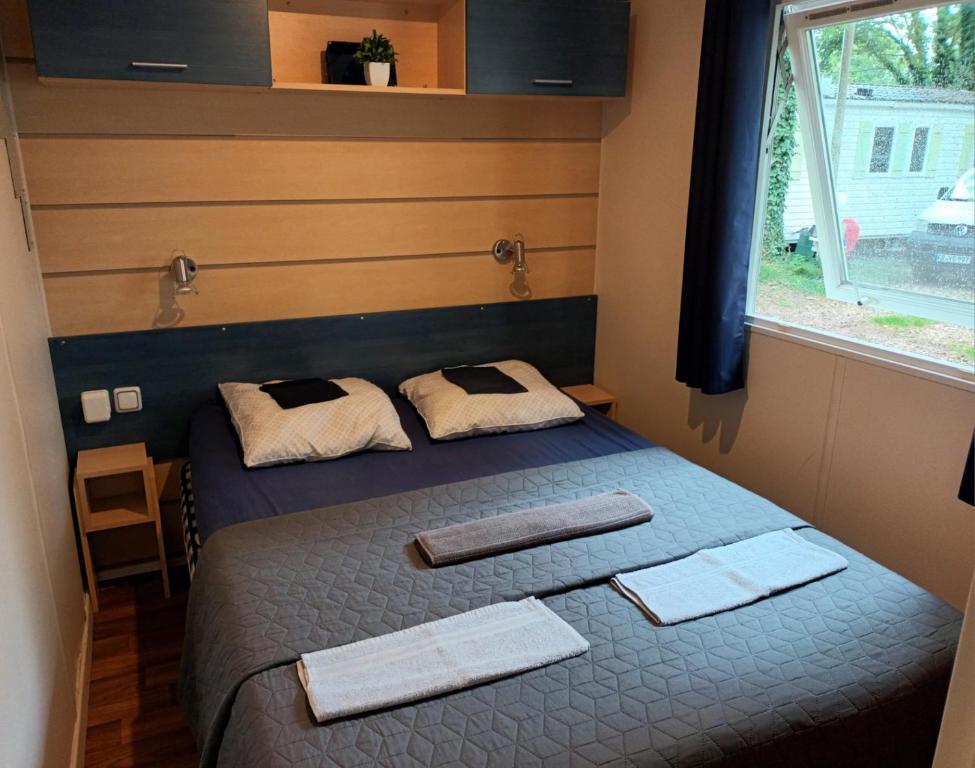 a bedroom with a bed with two towels on it at Mobil Home proche EUROPA PARK/RULANTICA in Boofzheim